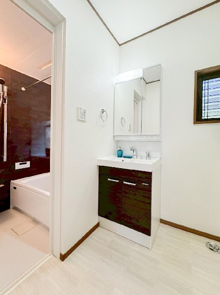 鏡の裏に収納棚を確保した三面鏡を採用。化粧品や歯ブラシなどを機能的に収納。また、三面鏡の本当の利点は三枚の鏡を合わせることで、頭の側面や背面が見れること。