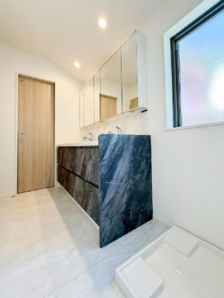 ゆとりの洗面スペースで朝の身支度も快適。三面鏡で髪のセットやお化粧もしやすい。朝から気分良く通勤通学に向かえそうですね！鏡の裏にはたっぷりと収納スペースがあるのでスッキリ片付きます。