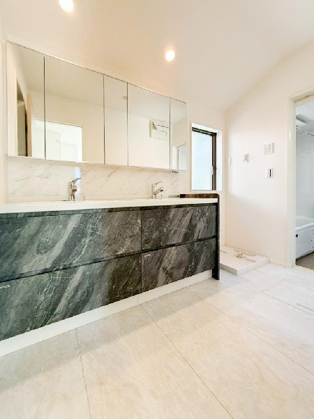 ワイドタイプの洗面台は忙しい時間に重宝するサイズ。鏡の裏に収納棚を確保した三面鏡を採用。化粧品や歯ブラシなどを機能的に収納。便利な床下収納付き。