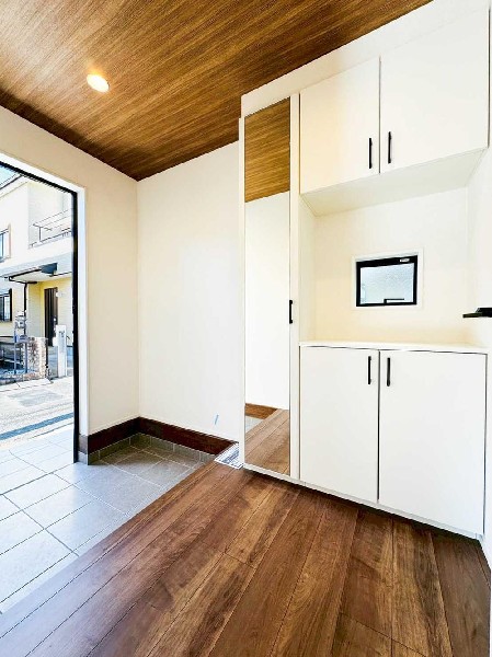 外観:木目天井が印象的な上質感ある玄関。大型シューズボックス付きで収納力も確保。すっきりとした空間が毎日の出入りを快適にします。