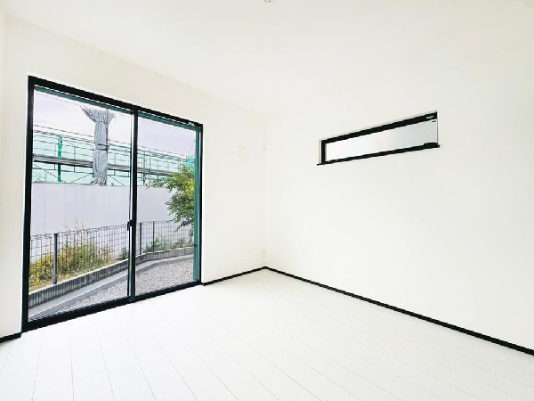 大きな窓から明るい光が差し込む爽やかな一室。外との距離が近く、庭スペースへの出入りもスムーズ。シンプルで家具配置もしやすい、心地よい居住空間です。