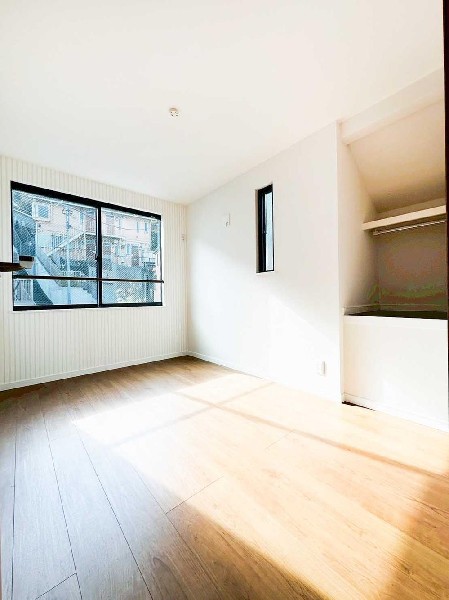 大きな窓から光が差し込む明るい洋室。オープンクローゼット付きで整理整頓がしやすく、室内を広く使えます。縦ラインのアクセント壁が空間に表情を加える、使い勝手の良い一室です。