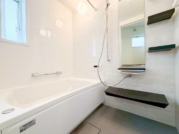 窓付きで明るさと換気が確保された清潔感あふれる浴室。落ち着いたアクセントカラーが空間を引き締め、ゆったりとくつろげるバスタイムを演出します。