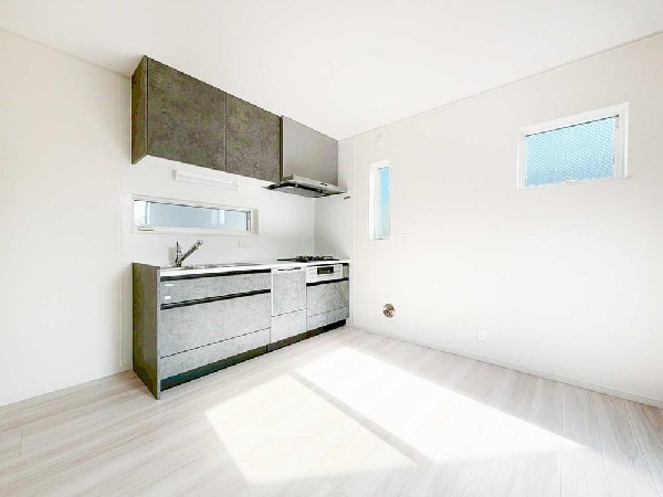 窓付きで明るさと通風を確保した壁付けキッチン。空間を圧迫しない薄型デザインで、LDK全体がすっきり広く見えるレイアウトです。