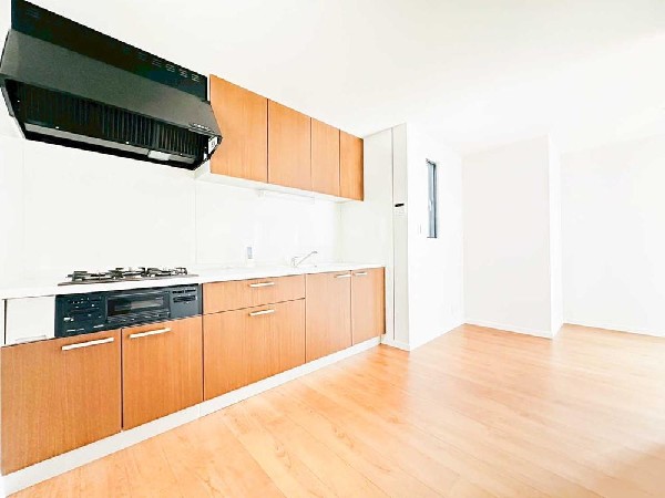 壁付けタイプならではの“広く使えるLDK”を実現したキッチン。横に長い作業台と豊富な収納で、調理も片付けも快適に。明るい木目と白の組み合わせが清潔感を演出し、毎日の料理が楽しくなる空間です。