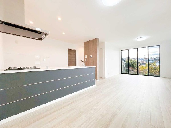 高台からの景色を楽しめる開放的なLDK。大開口窓が室内と外をつなぎ、空と街並みを身近に感じられる住まいです。