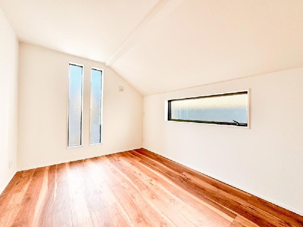 縦長スリット窓と横長窓をバランスよく配置した、建築美を感じる洋室。柔らかな自然光が差し込み、シンプルながら印象的な空間に仕上がっています。