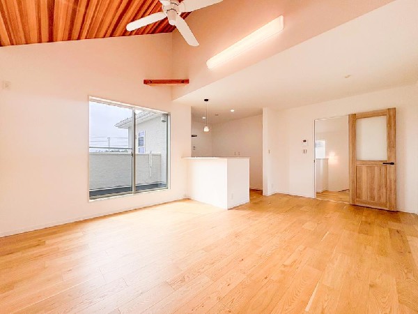 勾配天井が視覚的にも広がりをもたらす、開放感と高級感を演出するリビングです。木の温もりを感じるフローリングの優しい色合いが、居心地の良い空間に仕上げました。