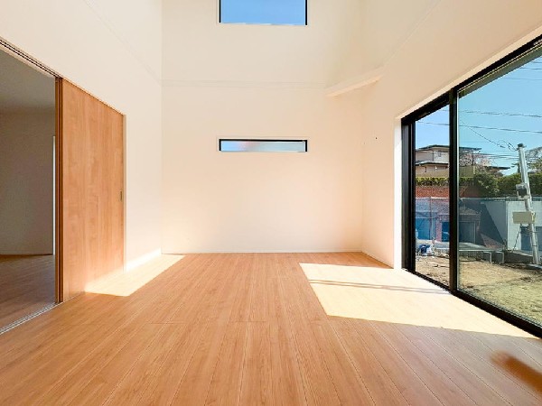 ２階層をひとつに繋げた吹き抜け。天井位置が高くなり、2階部分の窓から1階へと光を取り入れることができるため、明るく開放的な空間になっています。(Voidとも言う）