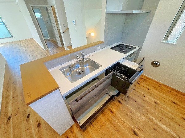 食事の受け渡しが楽にできる明るい対面式のキッチンカウンター。滑らかな動作で引き出しやすい、大容量のスライド式収納。