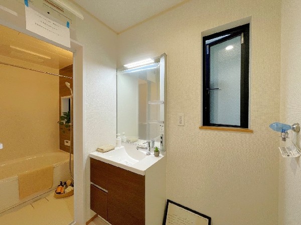 清潔感ある洗面室。シンプル仕様でスッキリした印象の洗面化粧台は大きさも十分。大きな窓もあり、換気も良好。
