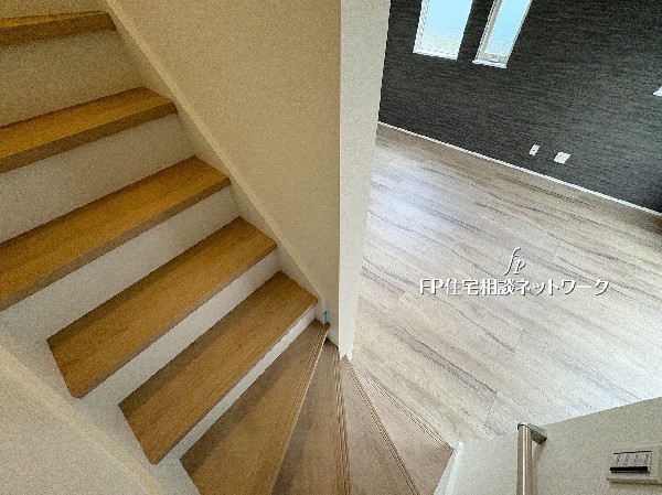 木の温もりを感じる階段が、リビングへとつながる心地よい動線を演出。明るい光と自然素材が調和し、家全体にやさしいぬくもりを広げます。