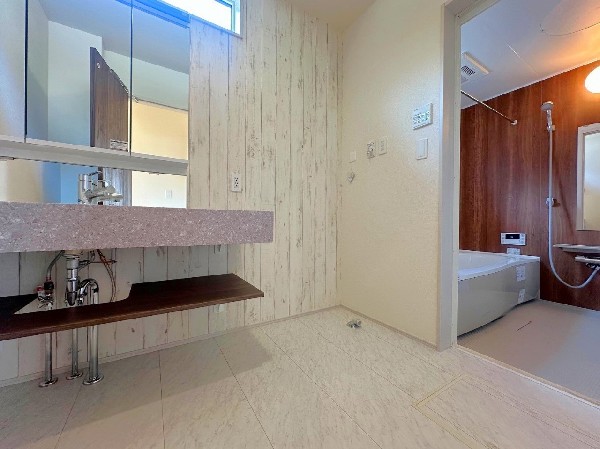 お洒落なアクセントクロスが印象的な広々洗面室は、汚れも目立たず快適です。洗練されたデザインと清潔感を保ちやすいフルフラットカウンター。