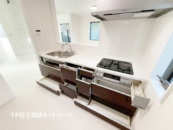 スライド収納付きのシステムキッチン。料理器具なども収納できて出し入れもスムーズ。収納量もたっぷりなので料理器具やストック調味料なども入れられる。