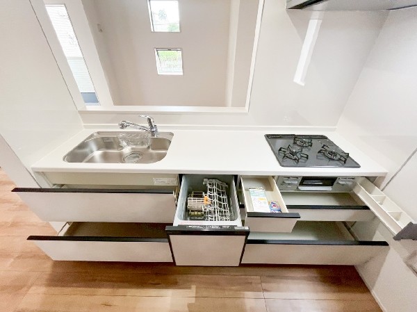 キッチンの天板の下部には容積の大きい深鍋やペットボトルなども楽に収納できる、便利なスライド収納を採用しました。