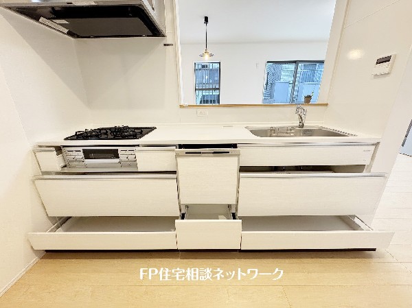 スライド収納付きのシステムキッチン。料理器具なども収納できて出し入れもスムーズ。収納量もたっぷりなので料理器具やストック調味料なども入れられる。