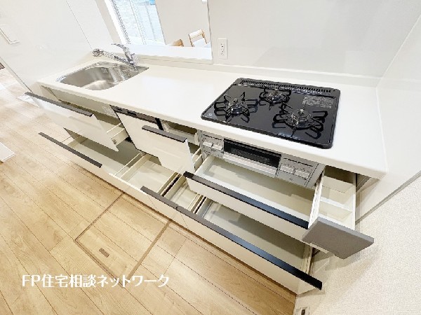 スライド収納付きのシステムキッチン。料理器具なども収納できて出し入れもスムーズ。収納量もたっぷりなので料理器具やストック調味料なども入れられる。