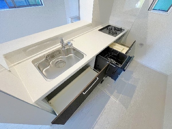 スライド収納付きのシステムキッチン。パスタ鍋や圧力鍋、フライパンなども収納できて出し入れもスムーズ。収納量もたっぷりなので料理器具やストック調味料なども入れられる。