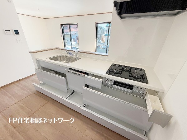 スライド収納付きのシステムキッチン。料理器具なども収納できて出し入れもスムーズ。収納量もたっぷりなので料理器具やストック調味料なども入れられる。