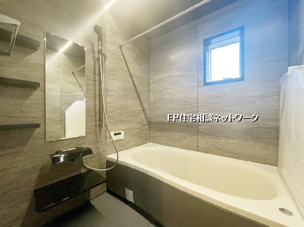 落ち着いた石目調のパネルが高級感を演出するバスルーム。ゆったり浸かれる広めの浴槽で一日の疲れをリセット。窓付きで換気もしやすい快適空間です。