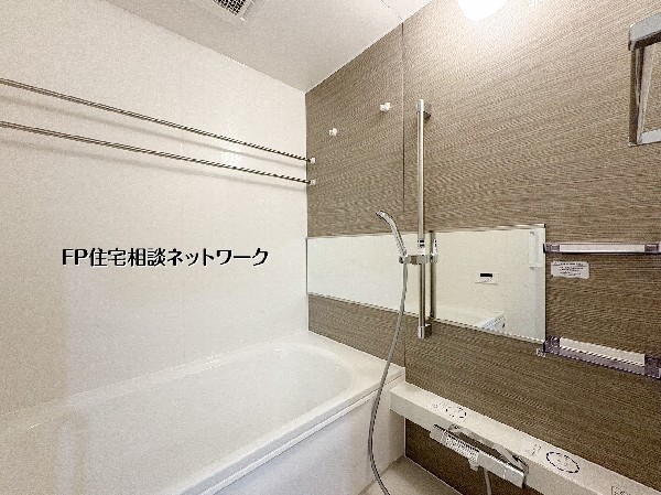 木目調のアクセントパネルが高級感と安らぎを与えるバスルーム。浴室暖房乾燥機用のランドリーパイプを備えており、雨の日のお洗濯も安心です。