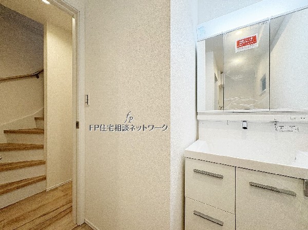 清潔感のある洗面化粧台。階段や廊下への動線もスムーズで、家事や身支度がしやすい配置です。