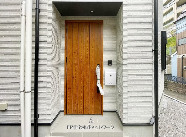外観:木目が美しい玄関ドアが印象的。  スタイリッシュな外壁とのコントラストが映える、温かみのあるエントランスです。