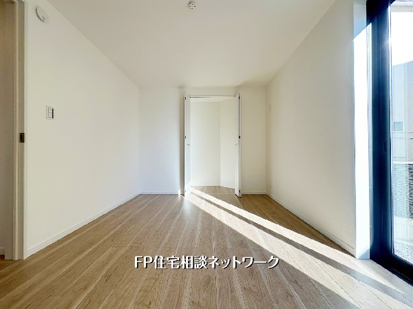 大きな窓から陽光がたっぷり差し込む心地よい洋室。明るい木目の床が空間を広く見せ、収納もしっかり確保された快適なプライベートルームです。