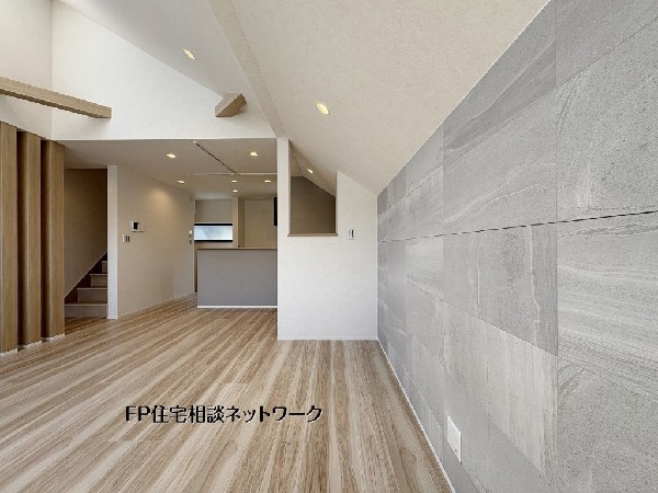 【LDK│18.3帖】  勾配天井が開放感を演出する、デザイン性の高いリビングです。アクセントウォールには石目調のタイルを採用し、上質なホテルライクな空間を創出。