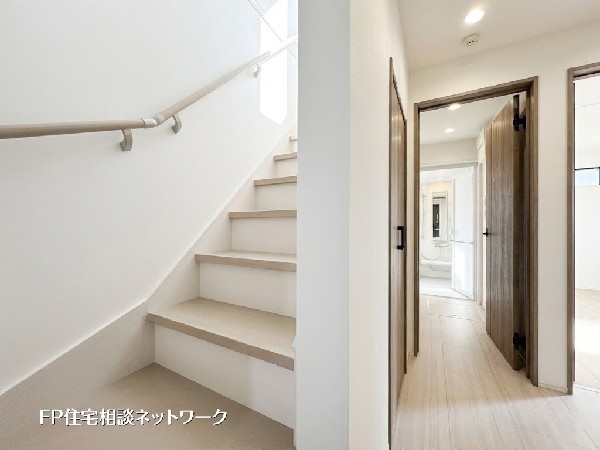 【玄関ホール】明るく清潔感のある玄関ホール。階段は手すり付きで安心して昇降でき、廊下奥には水回りを配置した使いやすい動線設計です。日々の生活を快適に支えます。