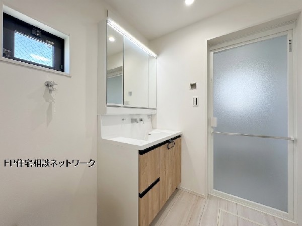 【洗面脱衣室】三面鏡付き洗面台を備えた清潔感ある洗面脱衣室。収納も充実しており、タオルや洗剤類もすっきり整理可能。窓付きで換気もしやすく快適にご利用いただけます。