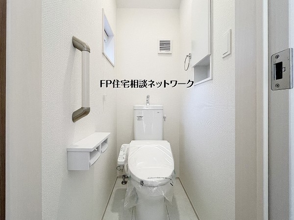 清潔感のあるトイレ空間には、窓付きで換気も良好。手すりや収納棚も備え、使いやすさと安心感に配慮された設計で、毎日快適にお使いいただけます。