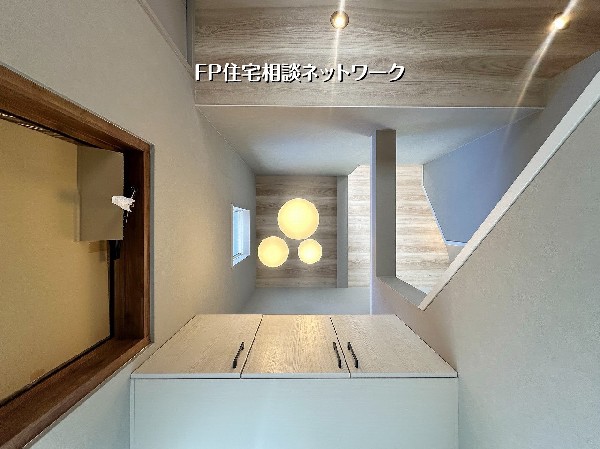 玄関は床から見上げる吹抜け設計。木目天井とやわらかな照明が空間に奥行きと開放感を演出し、帰宅するたびに心地よさを感じられる上質なエントランスです。