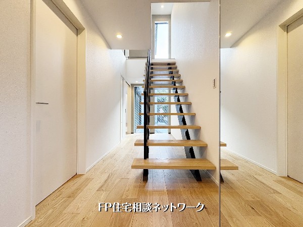 【玄関ホール】  玄関の主役は、黒いアイアンと木のコントラストが美しいスケルトン階段。視線が抜けるデザインが、空間に広がりと開放感をもたらします。光が通り抜ける、スタイリッシュで心地よい玄関ホールです。