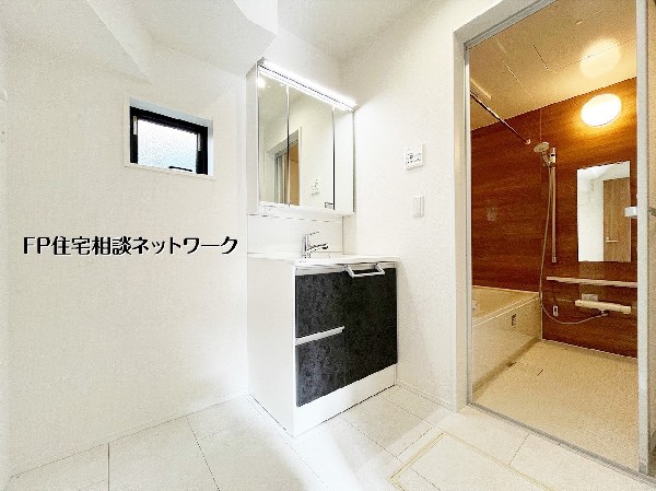 【洗面脱衣室】洗面室は浴室と隣接し家事動線が整った配置。三面鏡収納で日用品もすっきり収まり、窓付きで換気もしやすい清潔感のある空間です。 