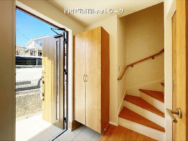 【玄関】  木目の温もりを感じる玄関が、優しく家族を迎え入れます。大型のシューズボックスを備え、常に整った空間を維持。明るい光が差し込む入り口から、心地よい毎日が始まります。