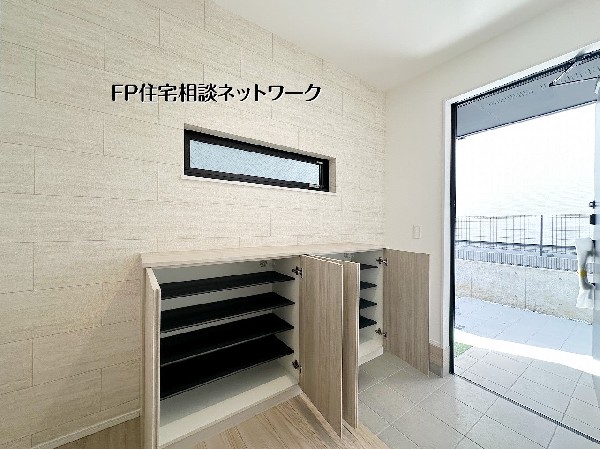 【シューズボックス】  可動棚付きのシューズボックスは靴の高さに合わせて収納可能。カウンター上は鍵や小物置きにも便利で、窓からの光が入るすっきりした玄関まわりです。