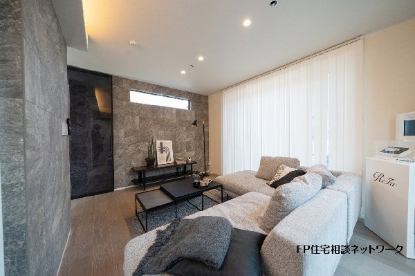 【プラン例　建物価格2200万円　建物面積100m2】石目調のアクセントウォールが印象的なリビング。落ち着いた色合いでまとめ、ゆったりくつろげる空間に仕上げました。