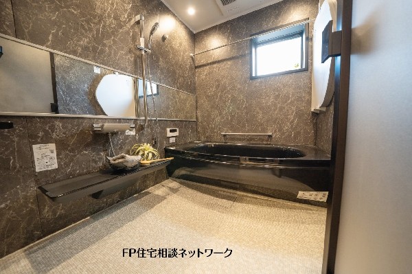 【プラン例　建物価格2400万円　建物面積100m2】重厚感のある壁面デザインで統一した浴室。落ち着いた色調でまとめ、毎日のバスタイムをゆっくり楽しめる空間です。