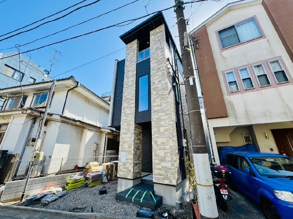 外観:建物の凹凸を利用し、面ごとに色や素材を張り分けています。石タイル調の外壁を縦に配置した個性的なデザインです。