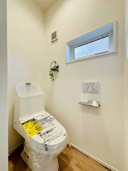 窓があるので陽ざしが入り明るいトイレ。洗浄機能付き便座を標準装備しています。1階と2階にあります。
