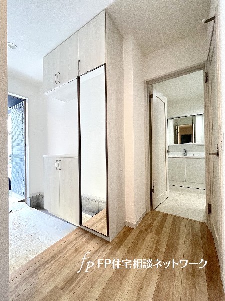 天井までの玄関収納付で、家族の履物が多くても安心。出勤前の身支度チェックに欠かせない姿見付です。