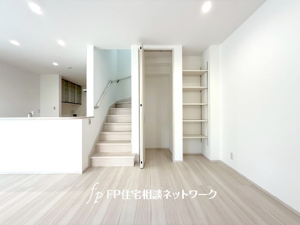 自然とご家族の交流が生まれるリビングイン階段。横に扉付きの収納スペースとオープン棚が設置され収納力○