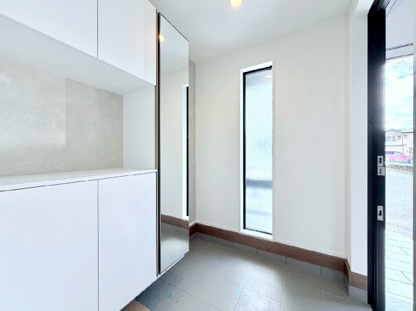 窓から自然光が射し込み訪れる人を心地よく迎え入れる。散らかりがちな玄関をスッキリと保てる玄関収納付。